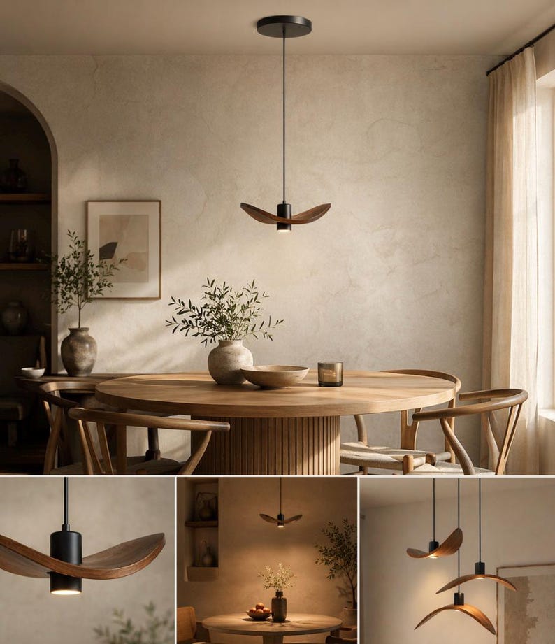 May include: A modern pendant light with a black base and a wooden, curved shade. The light hangs above a wooden dining table, creating a warm and inviting atmosphere. The room features neutral tones and natural elements.