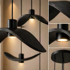 May include: Three black, modern pendant lights with a unique, curved design. Each light features a circular base with a downward-facing, warm-toned light. The lights are suspended from the ceiling by thin black cords, creating a stylish and contemporary look.