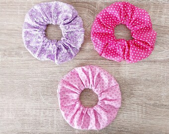 set of purple floral scrunchies, pink graphic