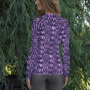 May include: A long-sleeved shirt with a purple dragon scale pattern. The shirt is fitted and has a crew neck.