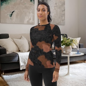 May include: A long-sleeved shirt with a brown and black abstract print. The shirt has a crew neck and a fitted silhouette.