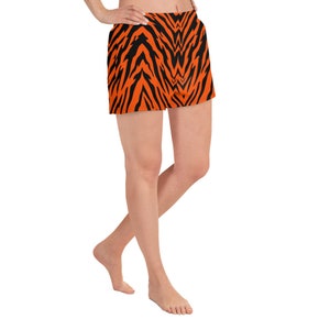 Puede incluir: Shorts deportivos naranja y negro con estampado de rayas de tigre.