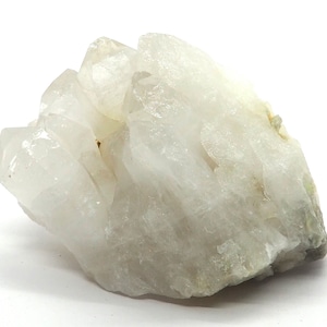 Peut inclure: Un amas de cristaux de quartz transparents avec une teinte blanc laiteux. Les cristaux sont regroupés dans une formation naturelle brute.