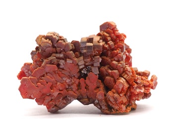 May include: A cluster of red and orange crystals with a rough, textured surface. The crystals are arranged in a random, organic pattern, creating a visually interesting and unique piece.