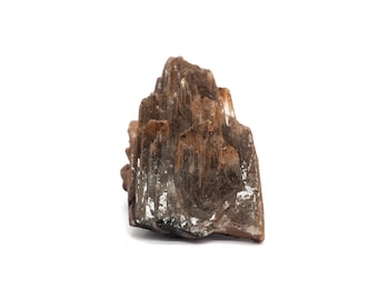 May include: A natural, rough-hewn stone formation with a layered, textured appearance. The rock features shades of brown and tan, with areas of white and gray. The overall shape is irregular, with a rugged, organic aesthetic. The stone is set against a white background.