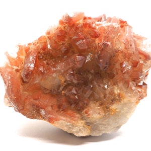 Peut inclure: Un amas de cristaux de quartz rouge avec une texture brute et naturelle. Les cristaux sont translucides et ont une teinte rouge-brun.