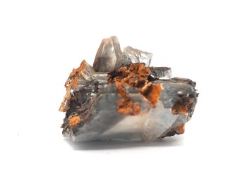 May include: A close-up of a mineral specimen featuring a cluster of translucent, light blue crystals. The crystals are accented with patches of orange-brown rust-colored material, set against a white background.