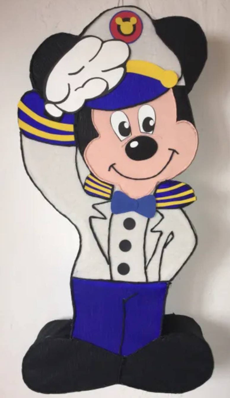 Puede incluir: Recorte de Mickey Mouse con uniforme de marinero. El personaje lleva una chaqueta blanca, pantalones azules y un gorro de marinero. El sombrero tiene un emblema amarillo y rojo. El personaje saluda con una mano enguantada blanca.