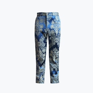 May include: A pair of tailored trousers with a blue and gold damask pattern. The pants have a classic fit with a button and zipper closure. The fabric has a subtle sheen, and the design features floral and scroll motifs.