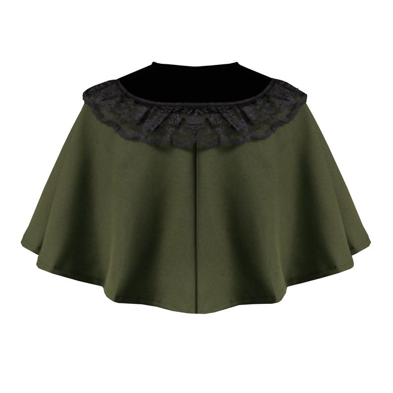 May include: An olive green capelet featuring a wide, rounded neckline adorned with a black lace trim. The garment has a flared, circular silhouette that drapes outward from the neck, with a visible vertical seam running down the center front.
