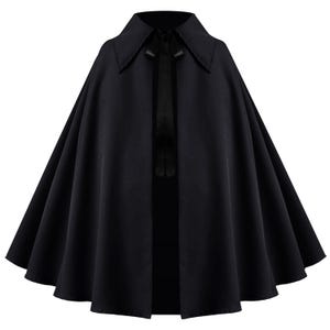 May include: A solid black cape featuring a wide, pointed collar and a matching black ribbon tie closure at the neckline. The garment has a flared, A-line silhouette that drapes in soft, vertical folds from the shoulders down to the hemline.