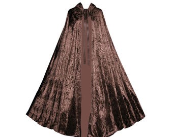 May include: A floor-length brown crushed velvet cape featuring a wide, flared silhouette and a smooth satin ribbon tie closure at the neckline. The fabric has a distinct textured, reflective sheen characteristic of crushed velvet material.