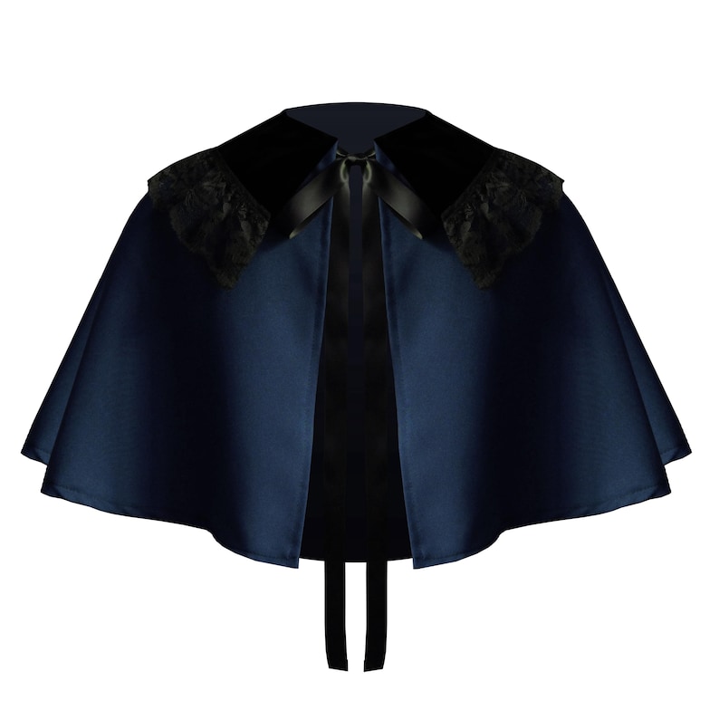 May include: A dark navy blue satin capelet featuring a wide black velvet collar with black lace trim on the shoulders. The garment is secured at the neckline with a black satin ribbon tie that hangs down the front, creating a structured silhouette.