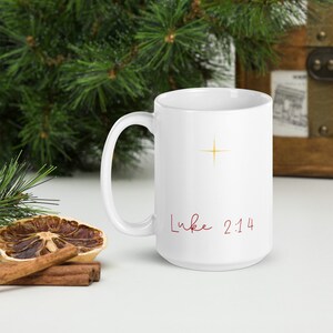 May include: White ceramic mug with a gold star and the text "Luke 2:14" in red cursive.
