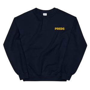 May include: A navy blue sweatshirt with a gold embroidered logo that says "PREDS".