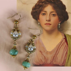 Puede incluir: Un par de pendientes dorados ornamentados. Cada pendiente presenta una perla en forma de lágrima, rodeada de perlas más pequeñas y cuentas doradas. Una piedra de color turquesa cuelga debajo. Los pendientes tienen una estética vintage.