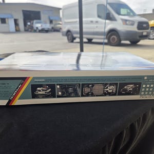 May include: A rectangular cardboard box for a Porsche 930 Turbo 78 model kit. The side panel features technical specifications, four small inset photographs showing the engine, interior, chassis, and exterior, and a German flag graphic.