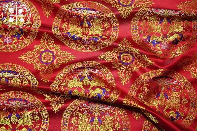 May include: Red fabric with a repeating pattern of gold and blue circular designs. The centre of each circle features a stylised image of a mythical creature.
