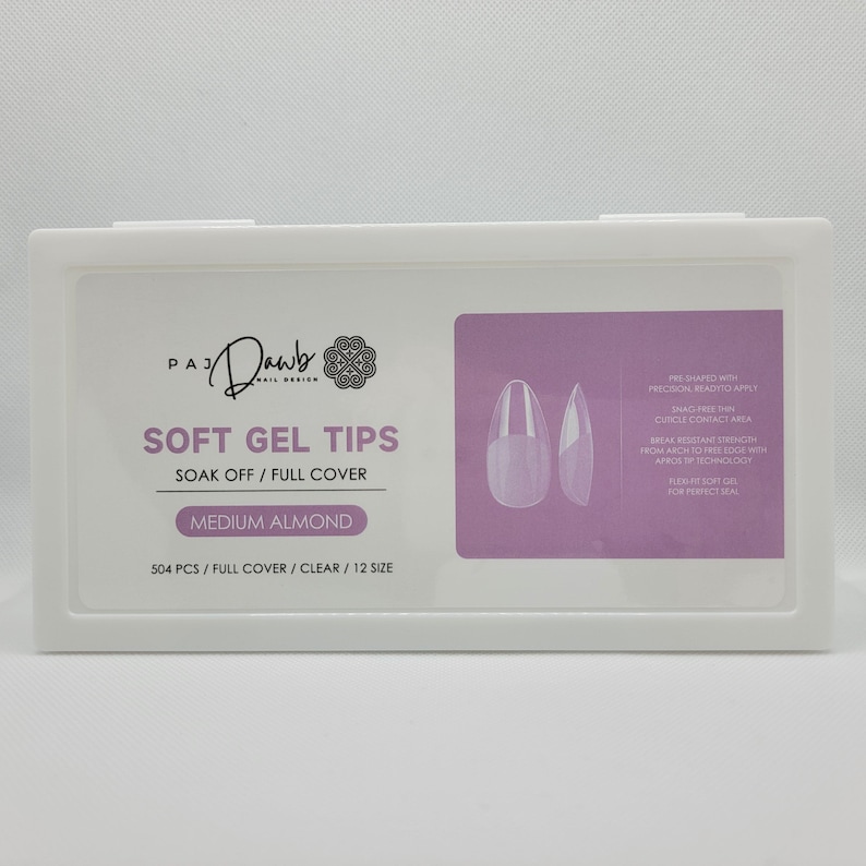 May include: A white box containing 504 clear, medium almond shaped soft gel nail tips. The box has a pink label with the text "PA Dawb Nail Design" and "Soft Gel Tips" in black. The label also says "Soak Off / Full Cover" and "504 PCS / FULL COVER / CLEAR / 12 SIZE".