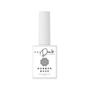 May include: A white bottle of rubber base nail polish with a black label that says "PAJ Dawb Nail Design" and "Rubber Base" with a black and white graphic of a heart. The label also says "Soak-Off UV/LED 15 ML."