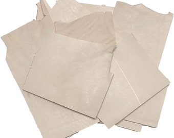 May include: A pile of off-white, textured paper sheets. The paper is slightly wrinkled and has a subtle sheen.