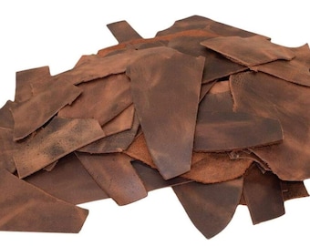 May include: A pile of brown leather scraps, perfect for crafting projects. The leather is a mix of different sizes and shapes, with a distressed, vintage look.