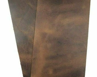 May include: Two pieces of brown leather, each with a different shade of brown. The leather has a textured surface and appears to be distressed.