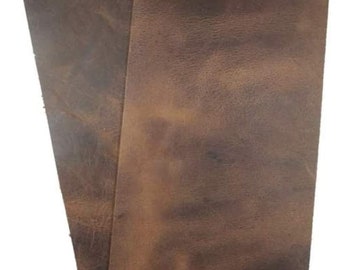May include: Two pieces of brown leather, each with a different texture and shade of brown. The leather is smooth and has a slight sheen.