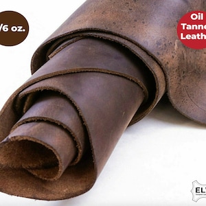 May include: A roll of 5/6 ounce oil tanned leather. The leather is a dark brown color and has a rough, textured surface.