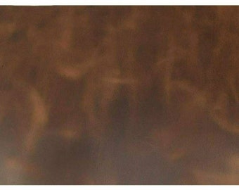 May include: A close-up of a brown leather texture with a subtle, mottled pattern. The leather has a smooth, slightly worn appearance.