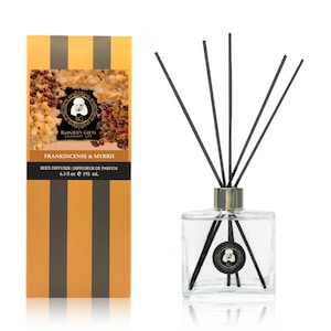 May include: A clear glass bottle with a gold lid and black reeds, filled with a light amber liquid. The bottle is labeled "Frankicense & Myrrh" and "Rainier's Gifts Celebrate Life". The bottle is 6.5 fluid ounces or 192 milliliters.