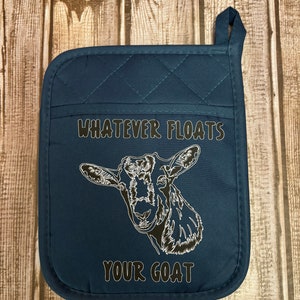 May include: A blue quilted pot holder with a white outline of a goat's head and the text "Whatever floats your goat".