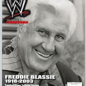 May include: A magazine cover featuring a smiling man in a black and white photo. The magazine is titled "World Wrestling Entertainment Magazine" with the WWE logo. The cover reads "Freddie Blassie 1918-2003 Twelve-Page Tribute Inside" and "August 2003".