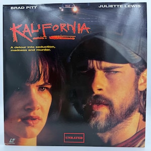 Puede incluir: Una carátula cuadrada de LaserDisc para la película Kalifornia con Brad Pitt y Juliette Lewis. El título está en texto rojo con el eslogan A detour into seduction, madness and murder. Se ve un coche arriba y un recuadro UNRATED abajo.