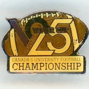 May include: A rectangular pin with a football design. It features the text "VANIER CUP 25" in gold and brown. Below, a banner reads "CANADA'S UNIVERSITY FOOTBALL CHAMPIONSHIP."