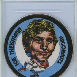 Puede incluir: Una tarjeta comercial calificada con una imagen de dibujos animados de Joe Theismann, un jugador de fútbol americano, con un uniforme azul y blanco de los Argonautas. La tarjeta es de 1971 Mac's Milk CFL. La tarjeta está calificada EX 5.