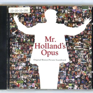 May include: A CD case for the "Mr. Holland's Opus" original motion picture soundtrack. The cover features a white silhouette of a person with outstretched arms over a collage of photos. The title is in burgundy, with the text "Original Motion Picture Soundtrack" below.