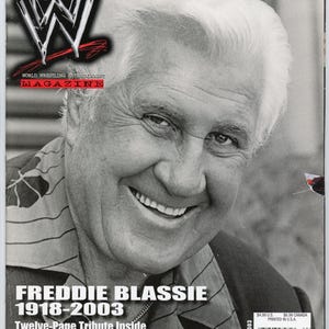 May include: A black and white magazine cover featuring Freddie Blassie, with the WWE logo at the top. The magazine is titled "World Wrestling Entertainment Magazine." The cover includes the text "Freddie Blassie 1918-2003 Twelve-Page Tribute Inside."