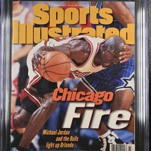 May include: A CGC graded 9.0 Sports Illustrated magazine from June 3, 1996, featuring Michael Jordan in a Chicago Bulls uniform dribbling a basketball. The cover text reads Sports Illustrated, Chicago Fire, and Michael Jordan and the Bulls light up Orlando.