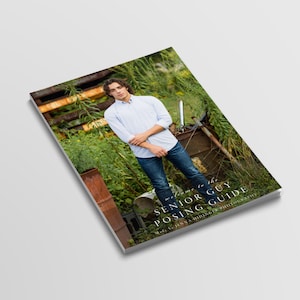 Op de afbeelding: Een boek getiteld "Welcome to the Senior Guy Posing Guide" met een jonge man in een lichtblauw overhemd en jeans. De achtergrond omvat groen en roestige metalen structuren. Het boek is schuin.