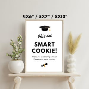 May include: A black and white printable sign with a graduation cap graphic and the text "He's one SMART COOKIE! Thanks for celebrating with us! Please enjoy some cookies." The sign is available in 4x6, 5x7, and 8x10 inch sizes.