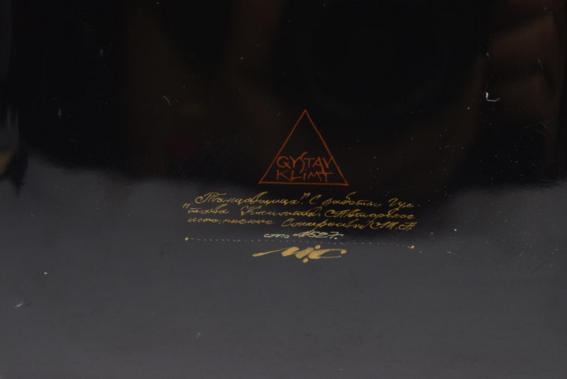 May include: A black background with gold lettering that reads "Gustav Klimt" in a triangle. Below the triangle is more gold lettering that reads "Плавник. 1. Собрание Украинского Фонда Современного искусства.  Киев. 1987."