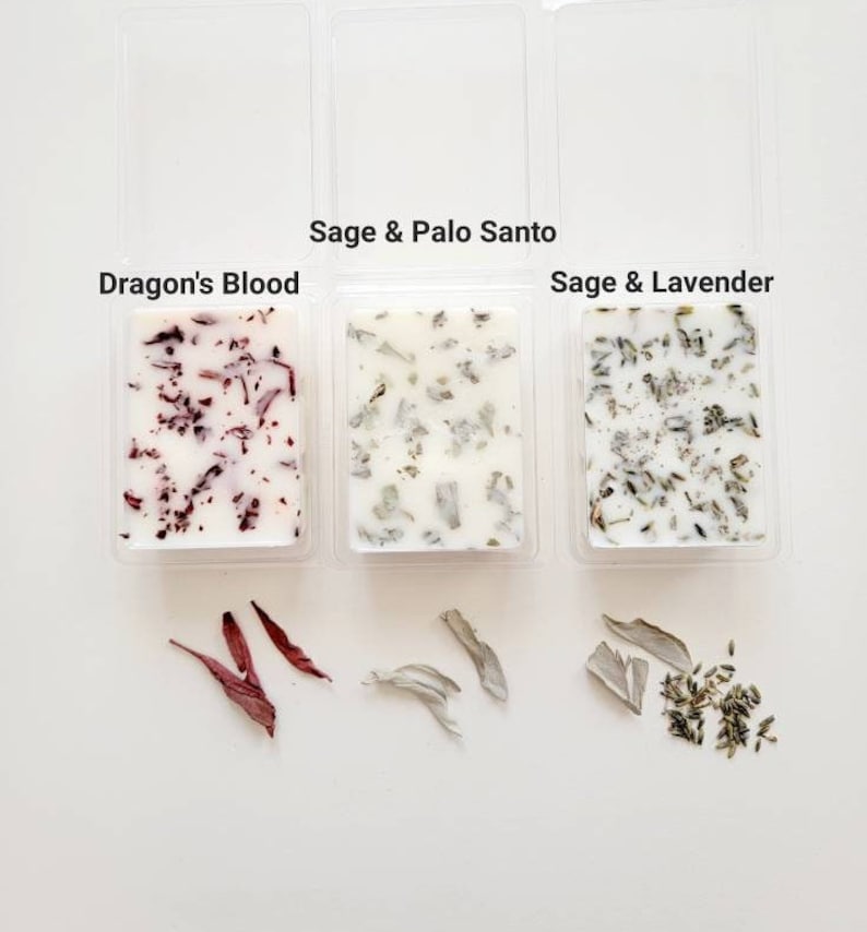 Pu&ograve; includere: Tre contenitori di plastica trasparente con cubetti di cera bianca. I cubetti di cera sono etichettati "Dragon's Blood", "Sage & Palo Santo" e "Sage & Lavender". Ogni contenitore ha un piccolo mucchio di erbe o fiori secchi di fronte.