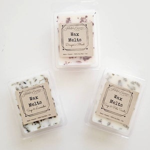 Pu&ograve; includere: Tre cere per profumare l'ambiente in contenitori di plastica trasparente. Le cere sono bianche e hanno un'etichetta marrone con il testo "Fabulous Essences" e "Wax Melts". I profumi sono "Dragon's Blood", "Sage & Lavender" e "Sage & Palo Santo".