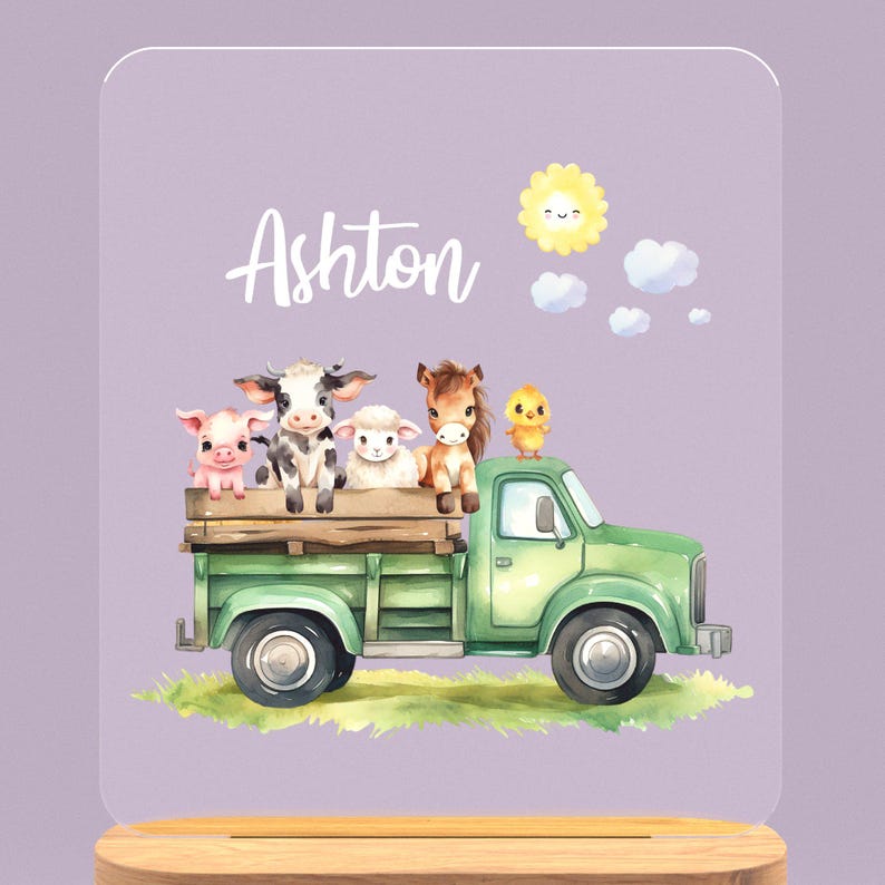 May include: A green toy truck with a white cab and a wooden bed. A pig, cow, lamb, and horse are sitting in the bed of the truck. A yellow chick is perched on the cab. The sun is shining in the sky above the truck. The name Ashton is written in white letters on a purple background.