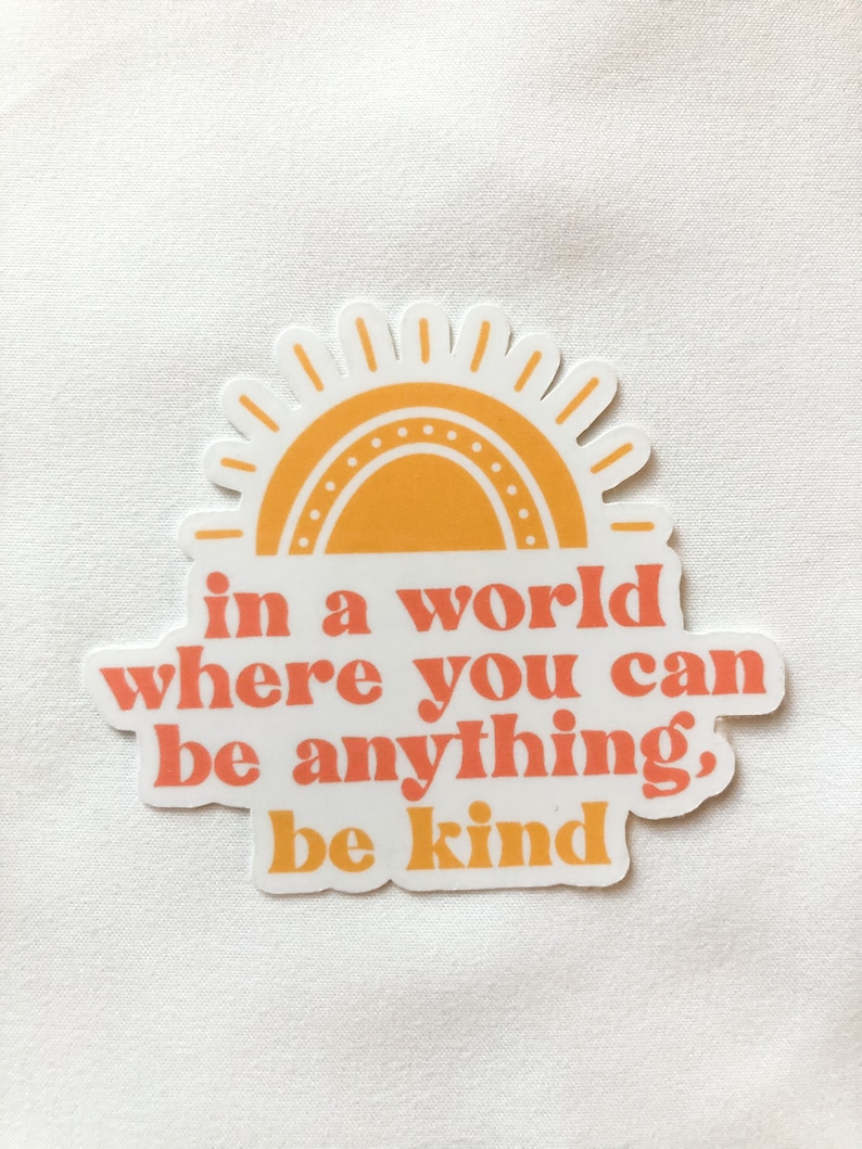 May include: A sticker with a yellow sun and the text "in a world where you can be anything, be kind".