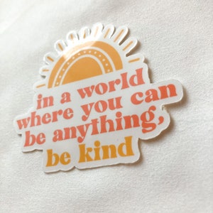 May include: A sticker with a yellow sun and the text "in a world where you can be anything, be kind".