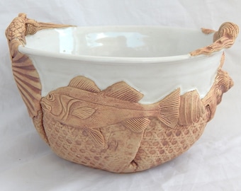 Handcrafted stoneware salad bowl with shells and other sea creatures in white glaze.