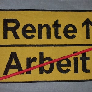 Op de afbeelding: Een geel bord met zwarte tekst die "Rente ↑" en "Arbeit" zegt, met een rode streep door het woord "Arbeit".