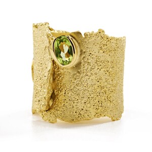 Anillo artesanal de diseño icónico, chapado en oro con textura y piedras preciosas de nacimiento: topacio azul, peridoto, amatista y granate.